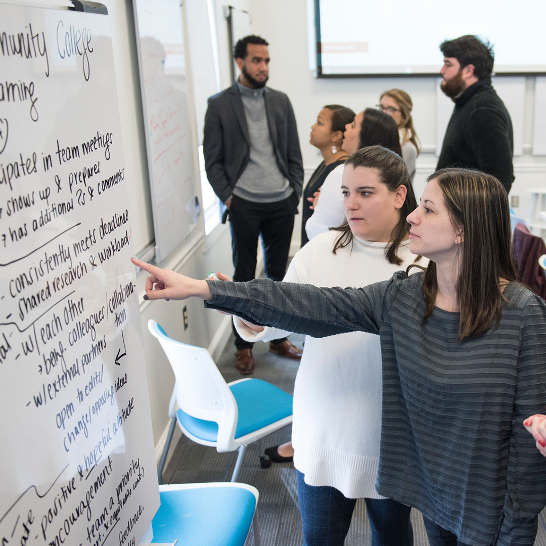 Elon education students looking at a project